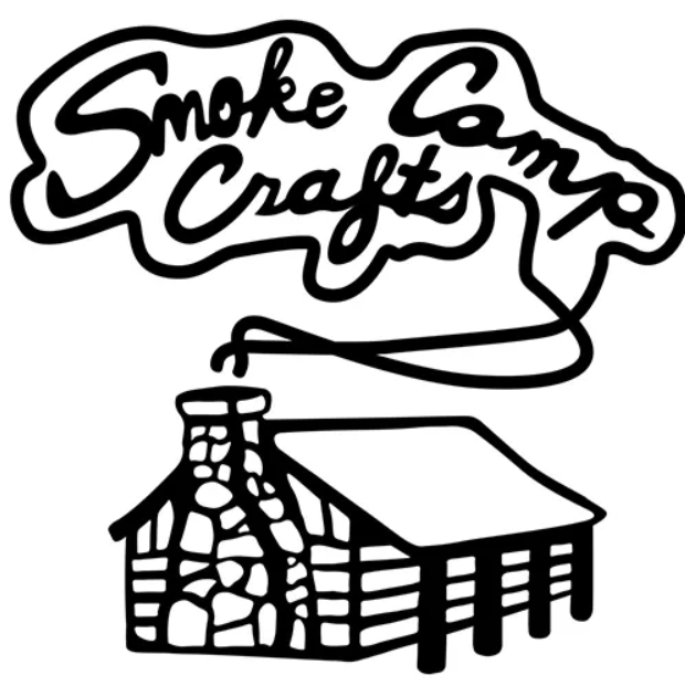 The black and white Smoke Camp Crafts logo shows a log cabin with a stone chimney. Smoke spells out “Smoke Camp Crafts” in playful script, while Buttonbush seed and wetland shrub motifs frame the scene, highlighting the native pollinator shrub.