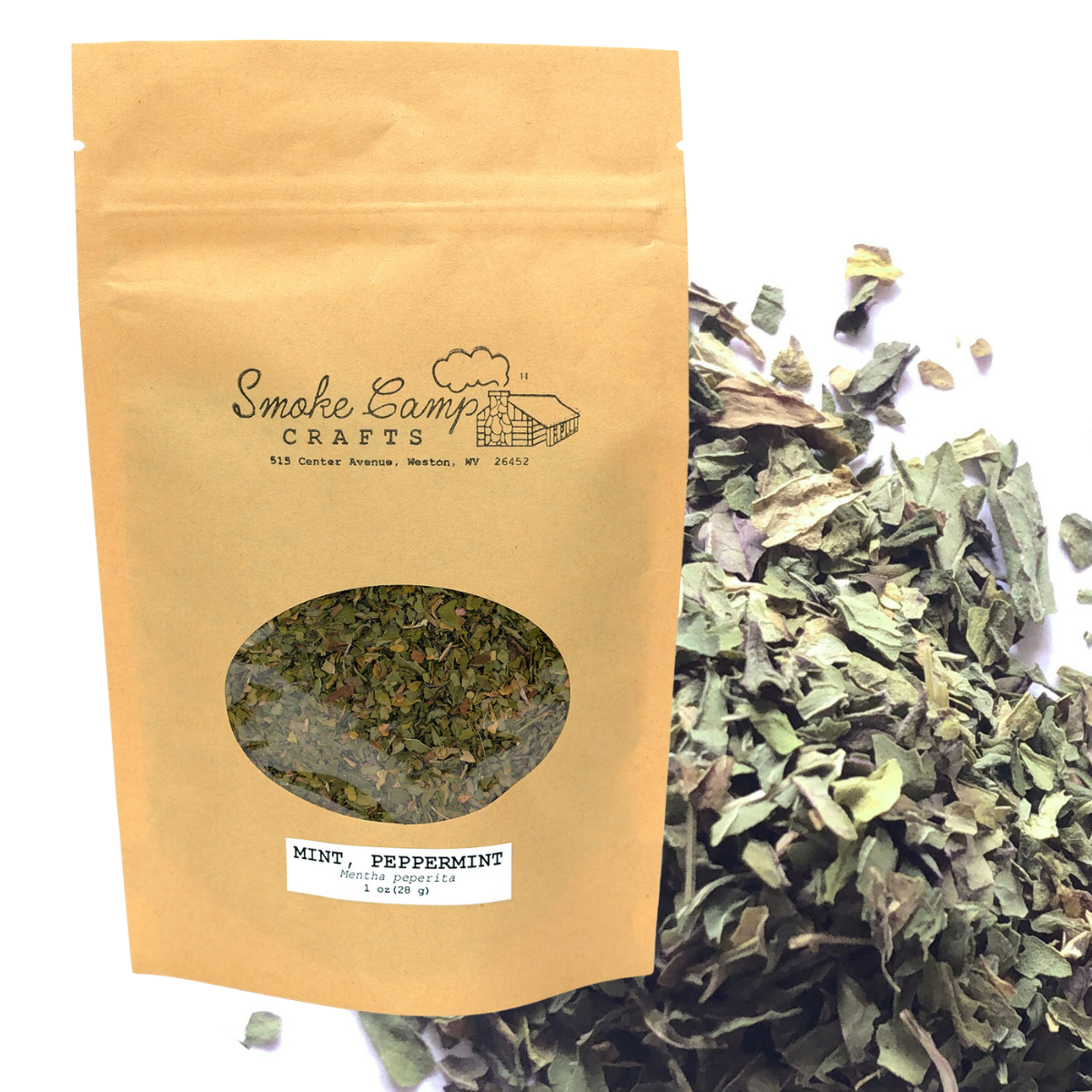A Smoke Camp Crafts brown paper bag labeled "Mint, Peppermint (Mentha peperita) Dried – Herb for Tea" contains dried leaves, visible through an oval window. Loose peppermint leaves, known to aid digestion, are scattered beside the bag.