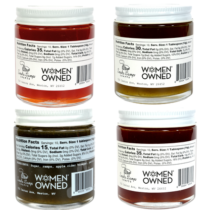 Smoke Camp Crafts Four Pack Jam & Jelly Gift Set features 5 oz jars of Ramp, Spiced Tomato, Green Pepper, and Hot Pepper jellies in amber to dark hues—each with a white lid and nutrition label displaying the "Women Owned" logo.