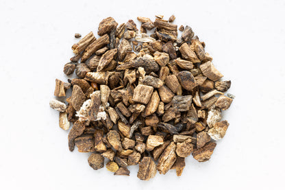 Smoke Camp Crafts Burdock Root, Dried, 1oz is displayed as a pile of small, irregular pieces arranged in a circle on a white surface.