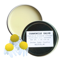 An open tin of Chamomile Salve, 1 oz by Smoke Camp Crafts sits beside three illustrated chamomile flowers—ideal for soothing skin care with natural, moisturizing ingredients.