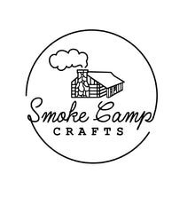 Black and white logo shows a log cabin emitting smoke inside a circle. “Smoke Camp Crafts” appears, with Smoke Camp in cursive above CRAFTS in capitals, evoking the cozy aroma of Cinnamon Sticks, Whole, 1oz by Smoke Camp Crafts.